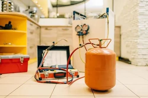 Refrigerant recovery tank and HVAC gauges set up for an air conditioning repair
