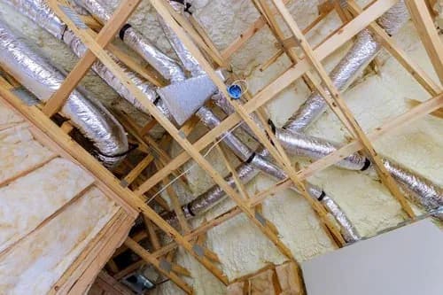 Insulated attic ductwork and spray foam insulation in a residential roof space