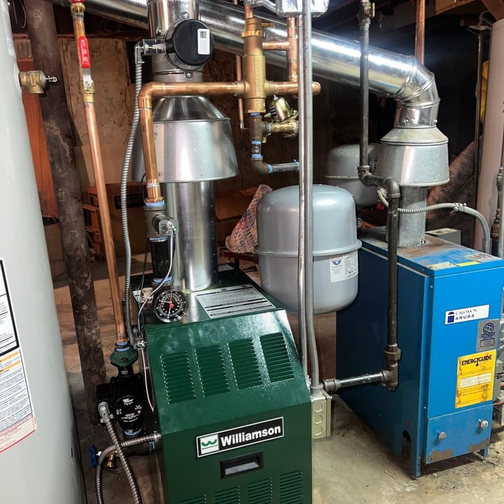 Weil-McLain gas boiler with copper piping and an expansion tank in a basement