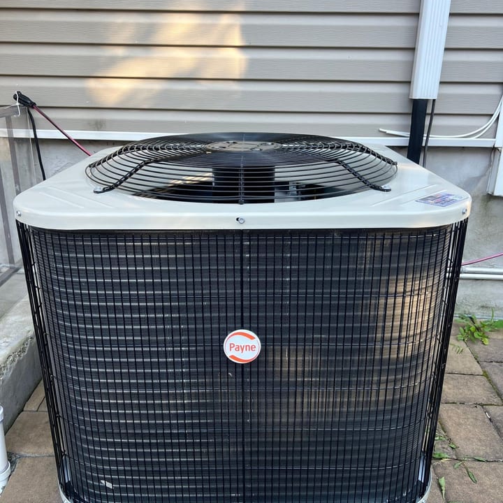 Rheem central air condenser installed on a level pad at a Staten Island home