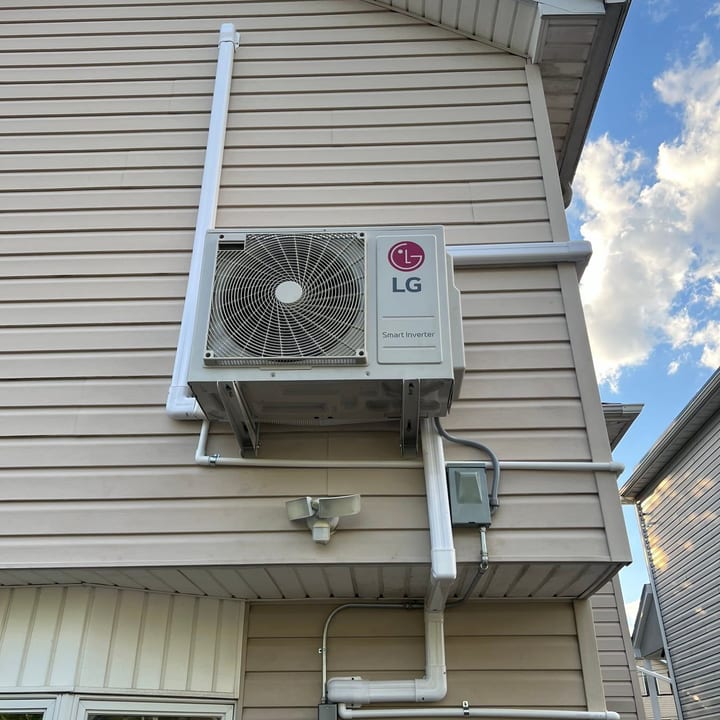 LG ductless mini-split outdoor unit wall-mounted on a two-storey home