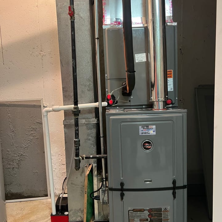 Rheem gas furnace installed in a basement utility room with new flue piping