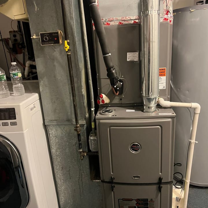 Gas furnace installed in a laundry room with new ductwork and vent piping
