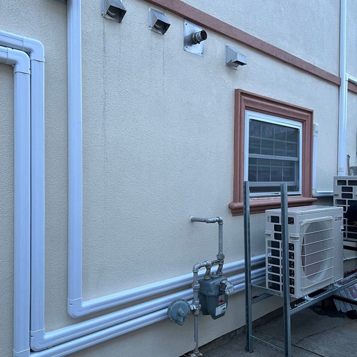 Line-set covers routed neatly along a stucco wall to a mini-split outdoor unit