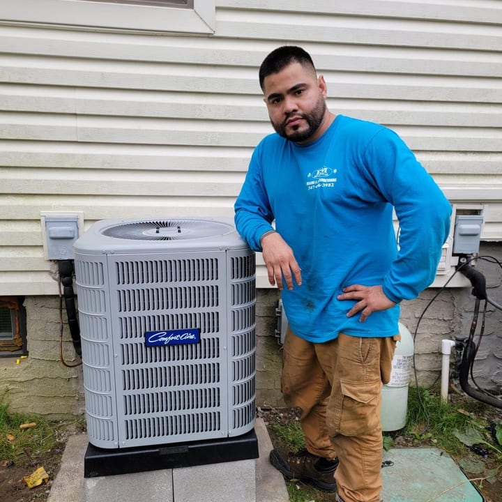 EM Mechanical technician standing beside a newly installed condenser