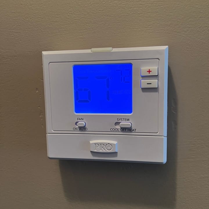 Programmable thermostat installed on an interior wall