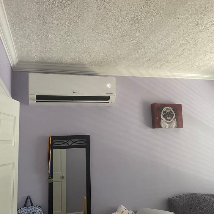 Ductless mini-split indoor unit installed high on a bedroom wall